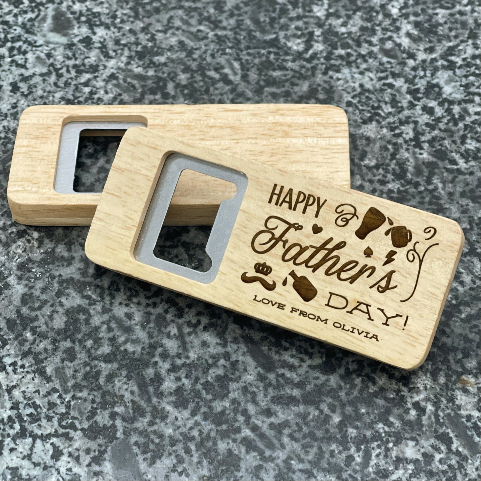 Father's Day Bottle Opener: Happy Father's Day. Pictured showing the engraved front and blank back, on a stone countertop