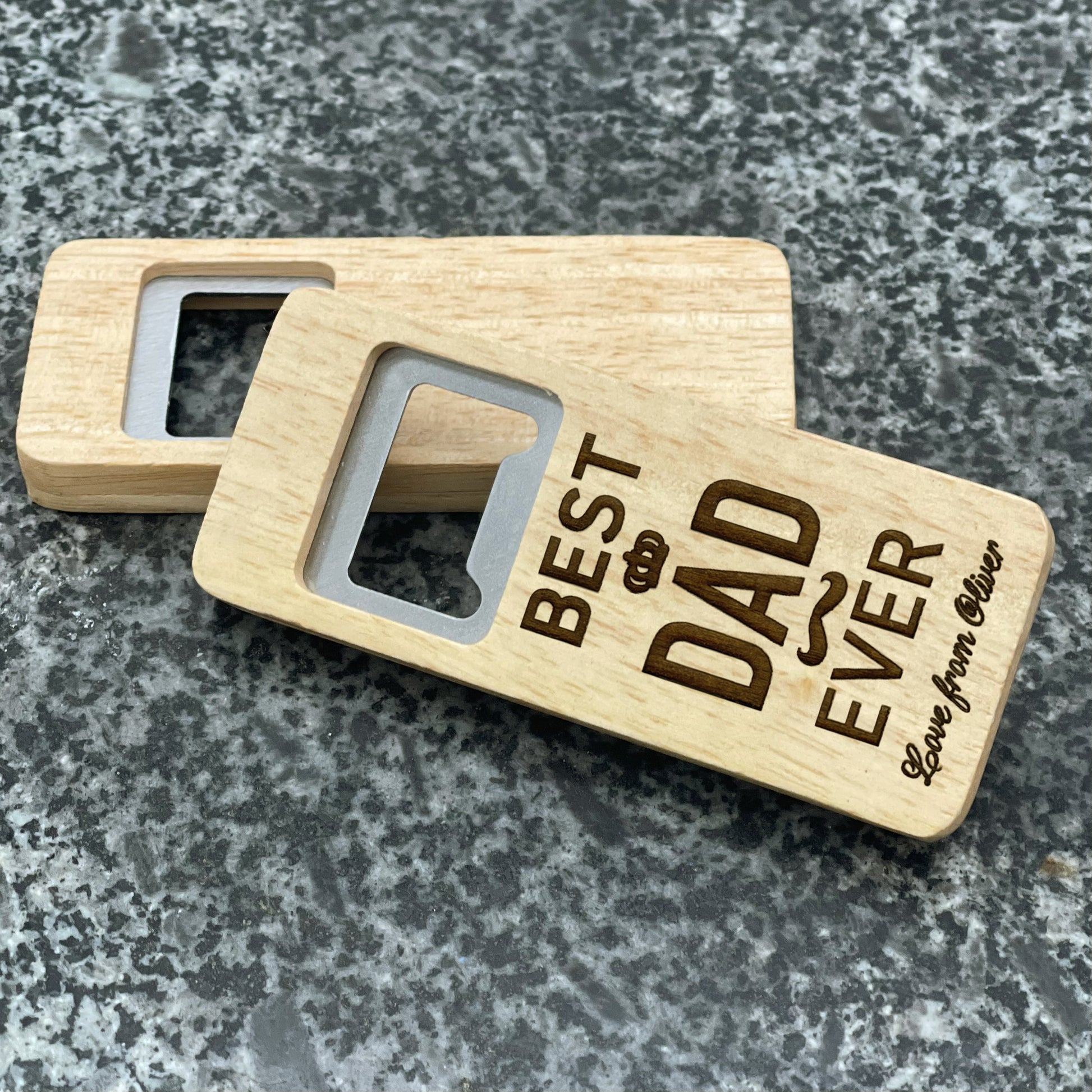 Father's Day Bottle Opener: Best Dad Ever. Pictured showing the engraved front and blank back, on a stone countertop